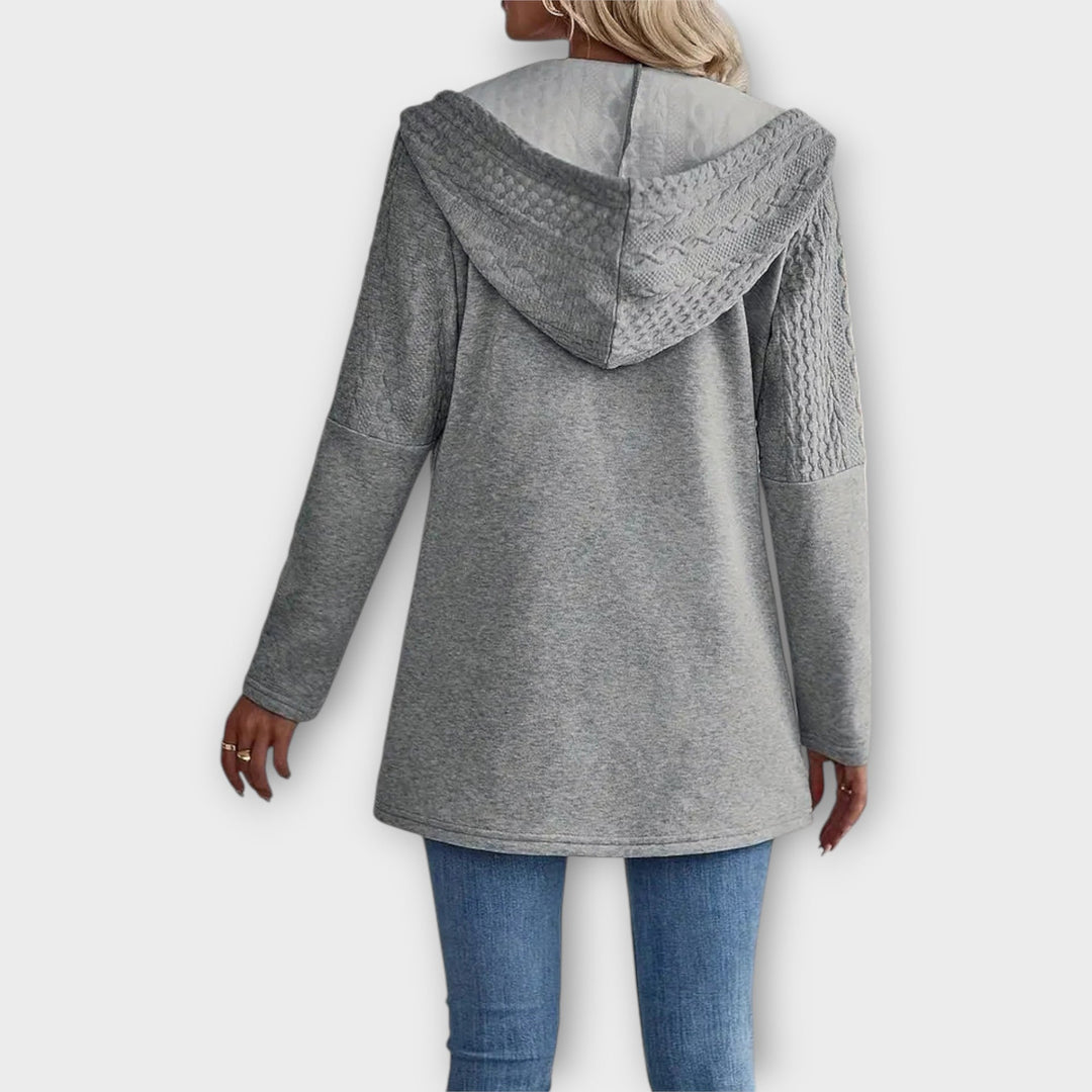 Stiilne kapuutsiga jakk modernsete detailidega.