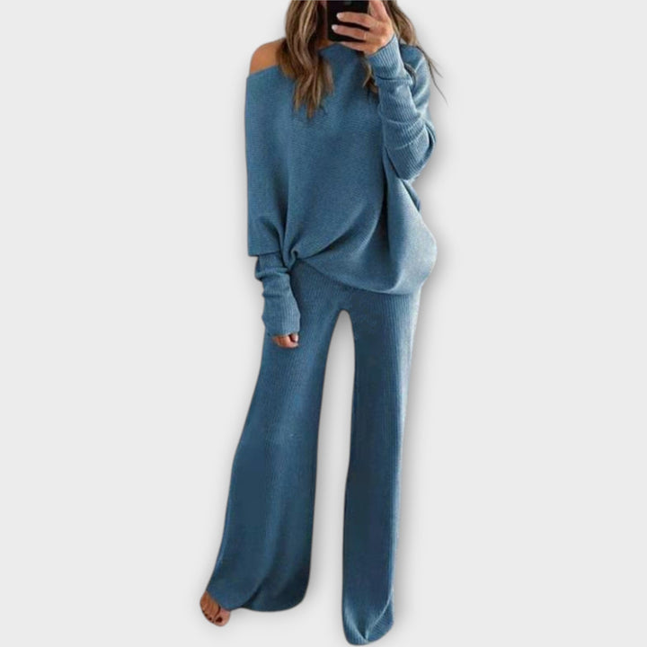 Kootud komplekt lahtise kampsuni ja laiade pükstega.